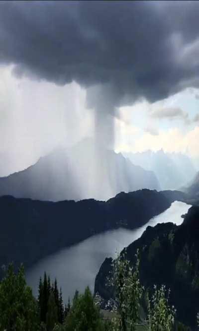 🔥 A massive down pour of rain moving over a moutian peak.