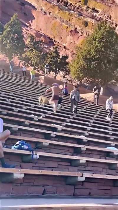 Man running down steps at Red Rocks Park backward.