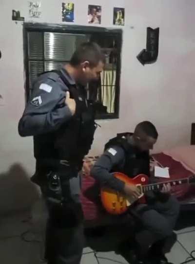 Brazilian cop playing suspect's electric guitar