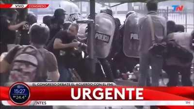 En las manifestaciones comtra el fmi, los manifestantes le tiraron una bomba molotov hacia la policia