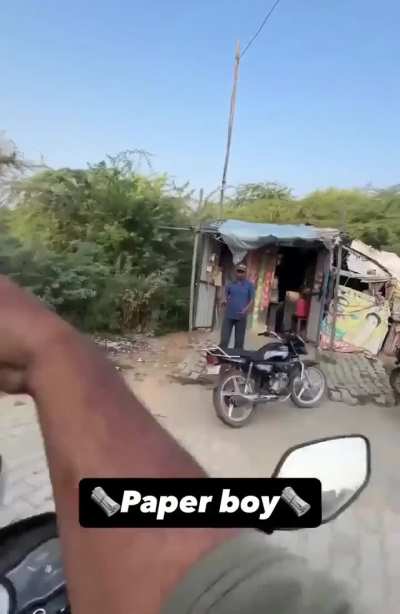 Paper boy with 17 years of experience tosses newspaper in India