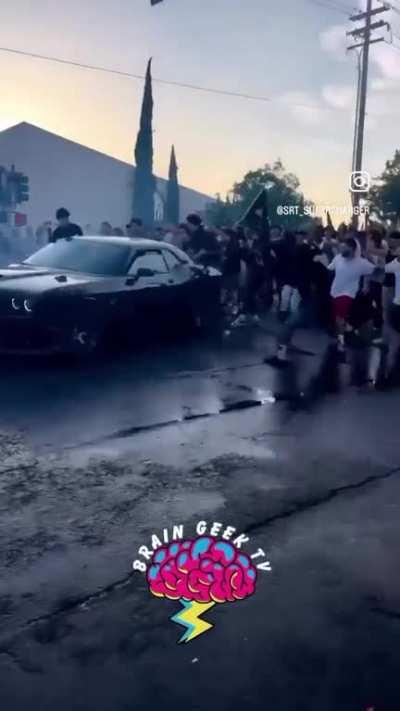 Car drifting in street runs into crowd