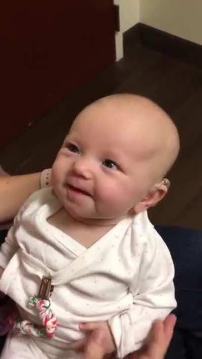 Baby hears mothers voice for the first time with the help of a hearing aid. the reaction is beautiful.