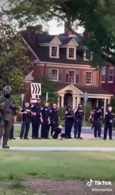 Police officer spits on arrested protester twice