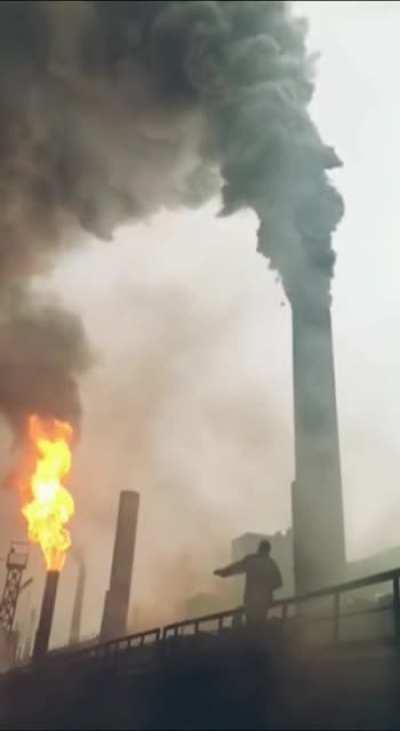 Throwing a torch into a smokestack to light it up