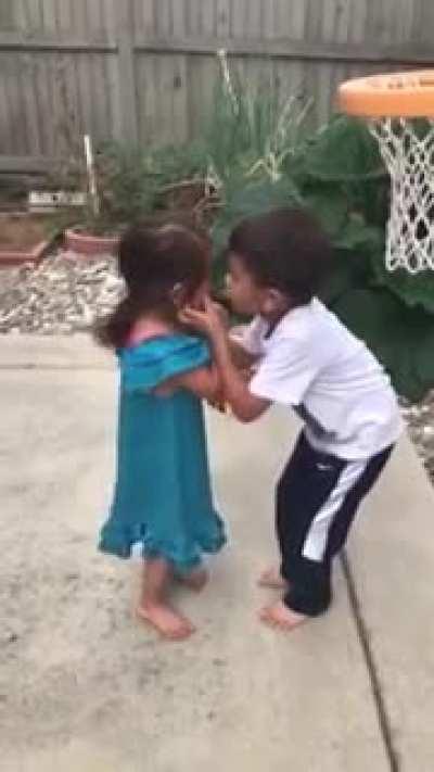 Brother helps little sister make the shot, everything's good