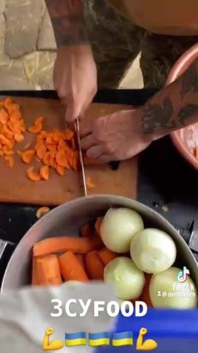Ukrainian military cook on the front lines keeps them soldier happy... Beat them mermite container meals.