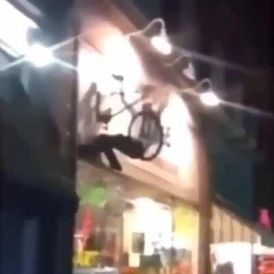 Man climbs on bike sign