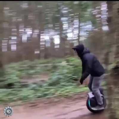 An electric unicycle riding dirt jumps