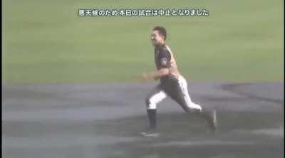 Taking advantage of a rain-out, Nippon Ham Fighter's Kenshi Sugiya runs the bases in a mudslide routine