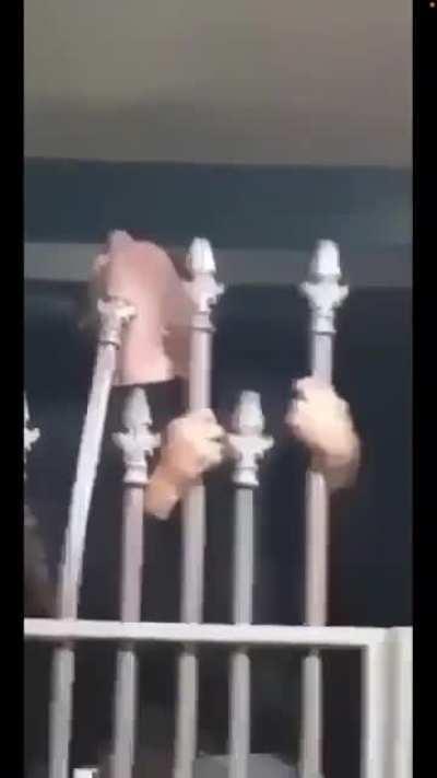 Idiot hangs like a Christmas ornament from a spiked fence