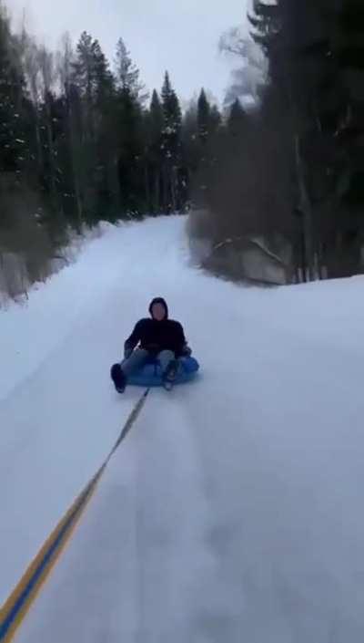 Idiot On Sled Getting Pulled By Car