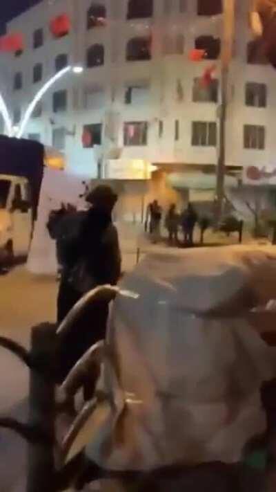 An Israel Defense Force soldier protecting a Palestinian woman