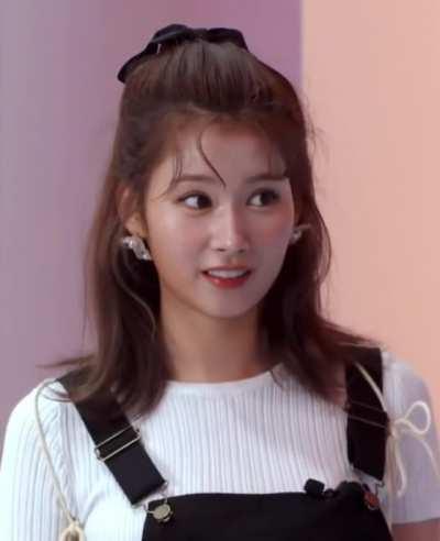 Sana - white top, black suspenders, confused