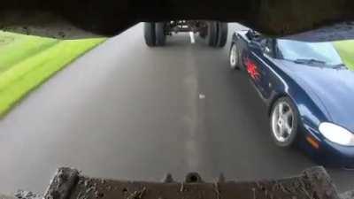miata driving underneath a Truck