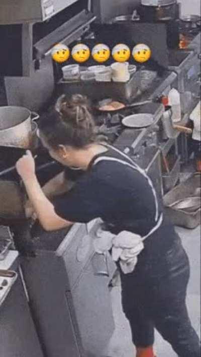 WCGW looking at the phone while working in a kitchen.