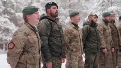 Soldiers from NATO countries — Denmark, Latvia, Spain, and the United States — sing 