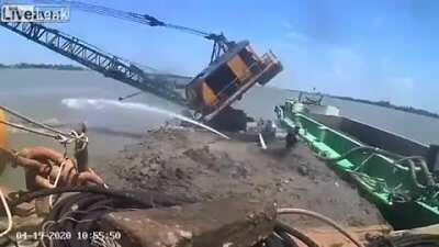 Excavator falls into the river