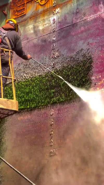 Powerwashing moss off a ship’s hull
