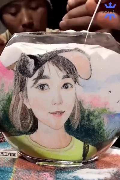 Making a portrait using colored sands inside a fish bowl