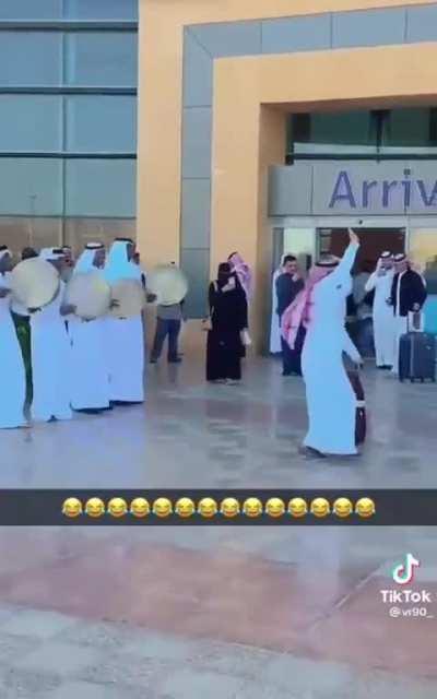 A traveler leaving the airport dances alone to a drum reception not knowing the context whatsoever