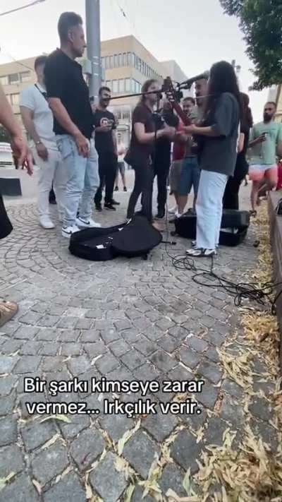 Racist Turkish woman has Freakout and threatens to call the police because a street performer is singing in Kurdish (in Germany).