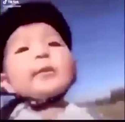 Asian kid falls from a bike