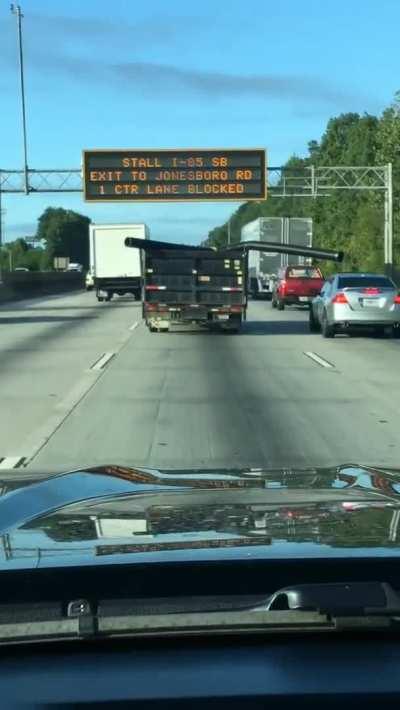 Construction truck with pipe hanging out the back hits passing vehicles.