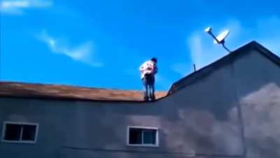 An addict does a backflip off a 3-story house and miraculously walks away while others watch.