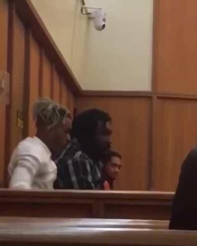 X getting escorted out of court.