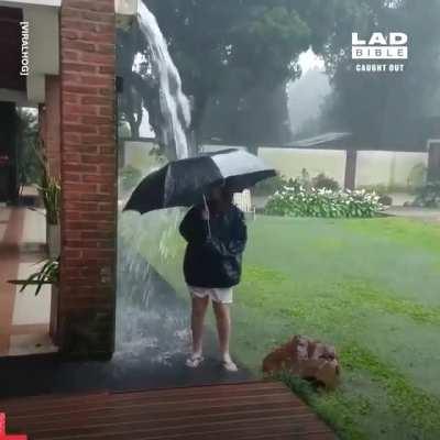 Standing outside in a storm with an umbrella