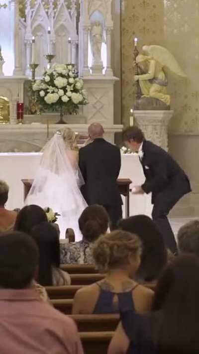 Best man fixes up the groom during wedding