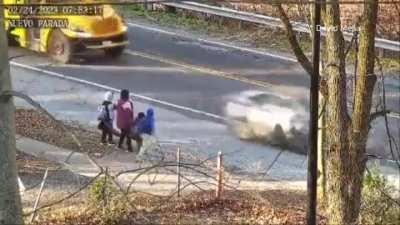 driver overtakes a stopping schoolbus by speeding in the shoulder, nearly hitting a mother and her kids