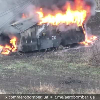 Drone footage of a stuck Russian assault shed. The vehicle was equipped with wood protection, rubber, drone netting, metal and EW systems. Ukrainian drone pilots were able to take out the crew and set the construct on fire.