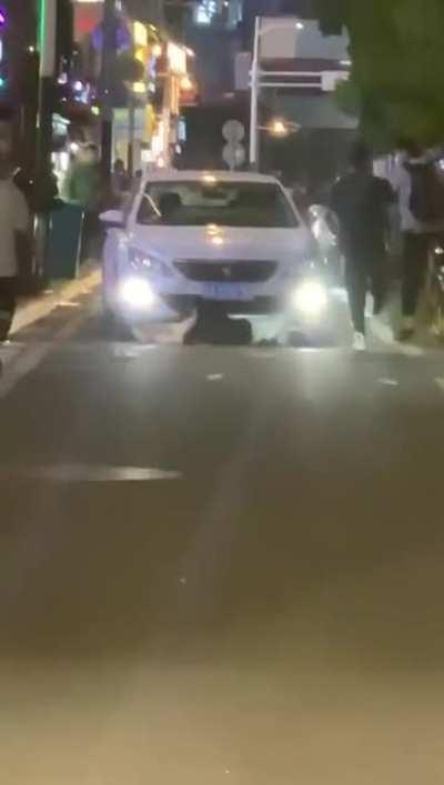 Driver calmly runs over a girl who's laying on the road.