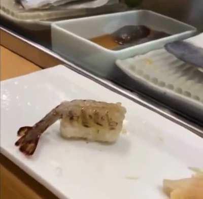 nigiri sushi that is still moving at the time it is served