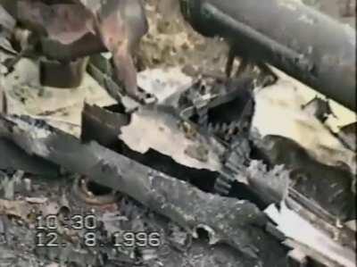 [Chechnya] Russian Soldiers extract the body of a tank crewman out of a T-72 after an armor column was ambushed on the outskirts of Grozny. August of 1996. *NSFW*