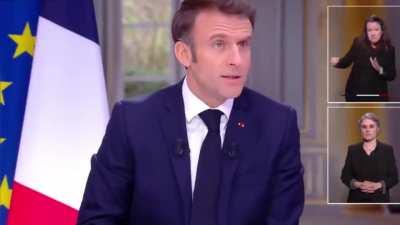 Macron is in an interview asking for sacrifices from French people but realizes he is wearing a $90,000 watchand like a magician makes it dissappear under the table