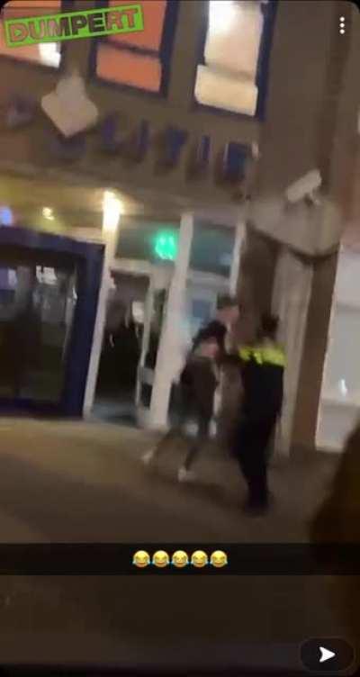 Guy peeing against a police station