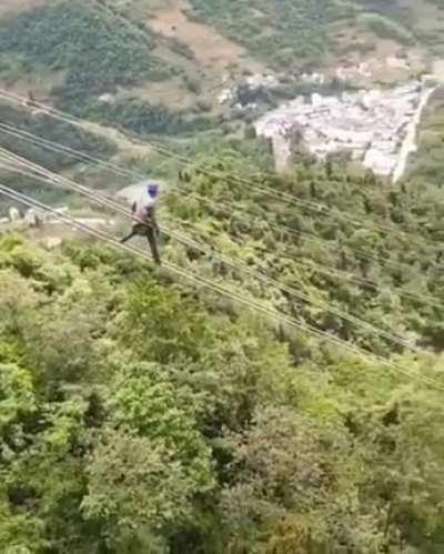 Lineman sliding down power lines