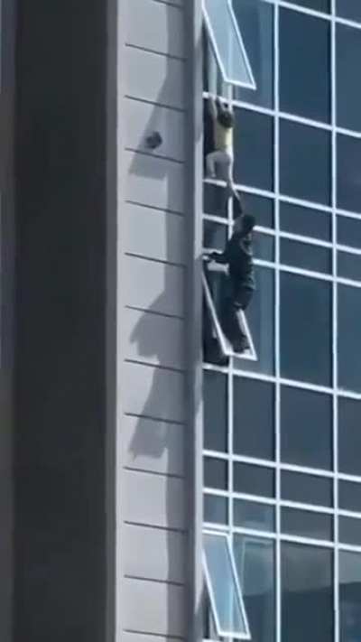 The man climbed out of his eighth floor apartment window to catch the helpless three-year-old girl.