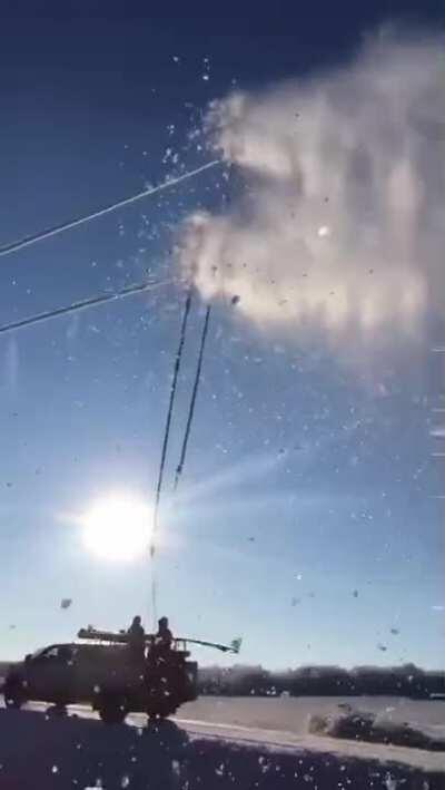 Scraping ice off power lines