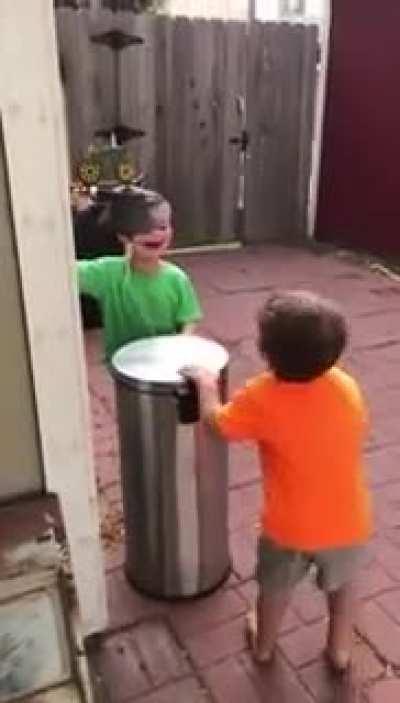 Kids hitting each other's head with trashcan lid