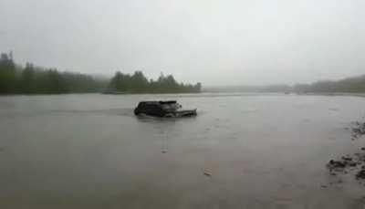 Group of friends driving SUV in a river..