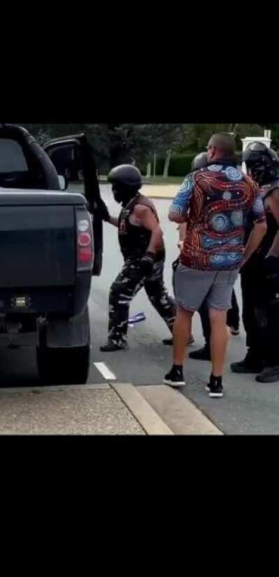 A person wearing a MAGA hat being forcefully removed by bikers at an Australia day protest. Bigotry is not welcome here.