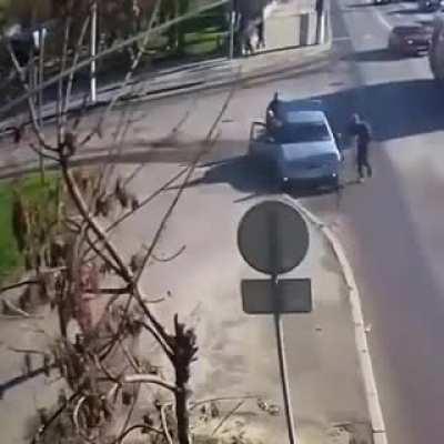 Motorcyle skids out and erupts into flames, enveloping it's rider. Luckily, the grey car driver knew exactly how to handle this situation.