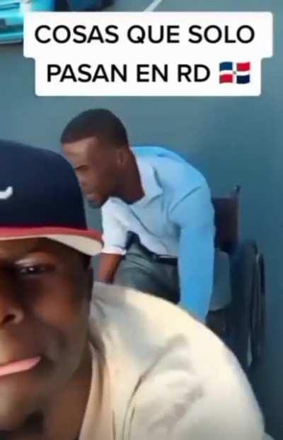 Man on wheelchair does a wheelie on a highway