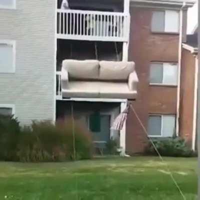Moving a couch off the top floor.