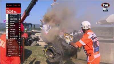 Italian marshalls passionately extinguish Stroll's car while it's still hanging off the crane