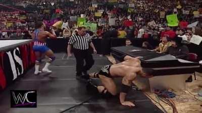 Kurt Angle gets on the mic mid match and complains about getting booed. The Rock responds.